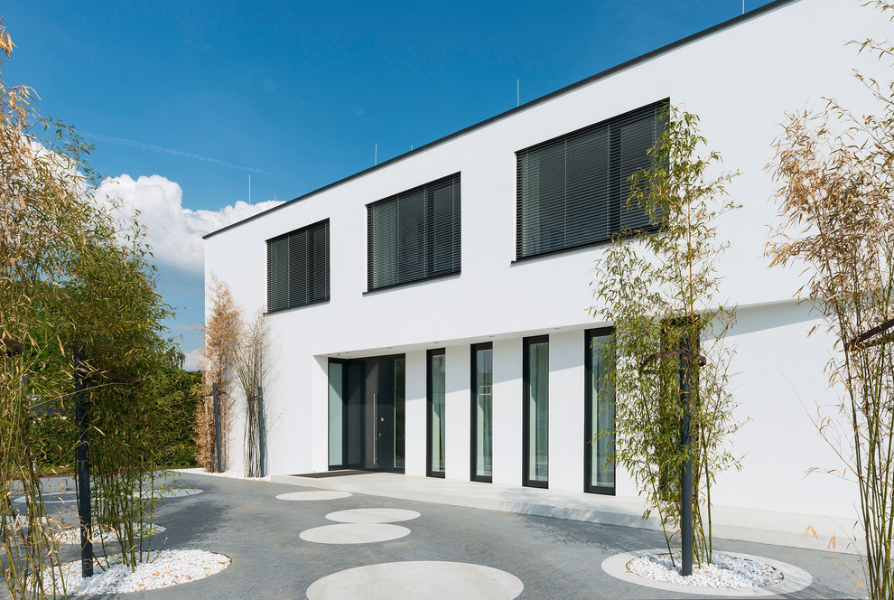 This is an example of a mid-sized contemporary two-storey stucco white house exterior in Dusseldorf with a flat roof.