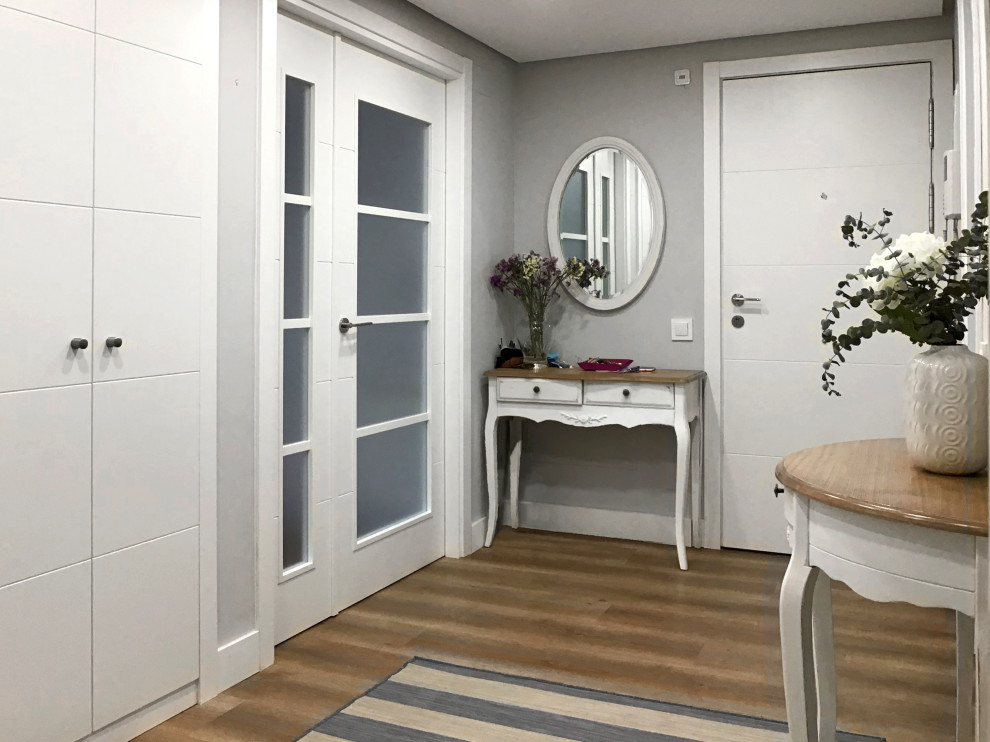 Imagen de distribuidor clásico renovado grande con paredes grises, suelo laminado, puerta doble, puerta blanca y suelo gris