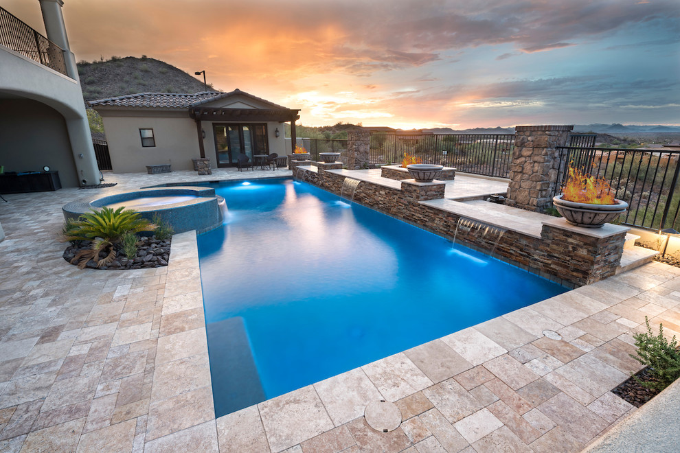 Example of a large minimalist backyard stone and custom-shaped pool fountain design in Phoenix