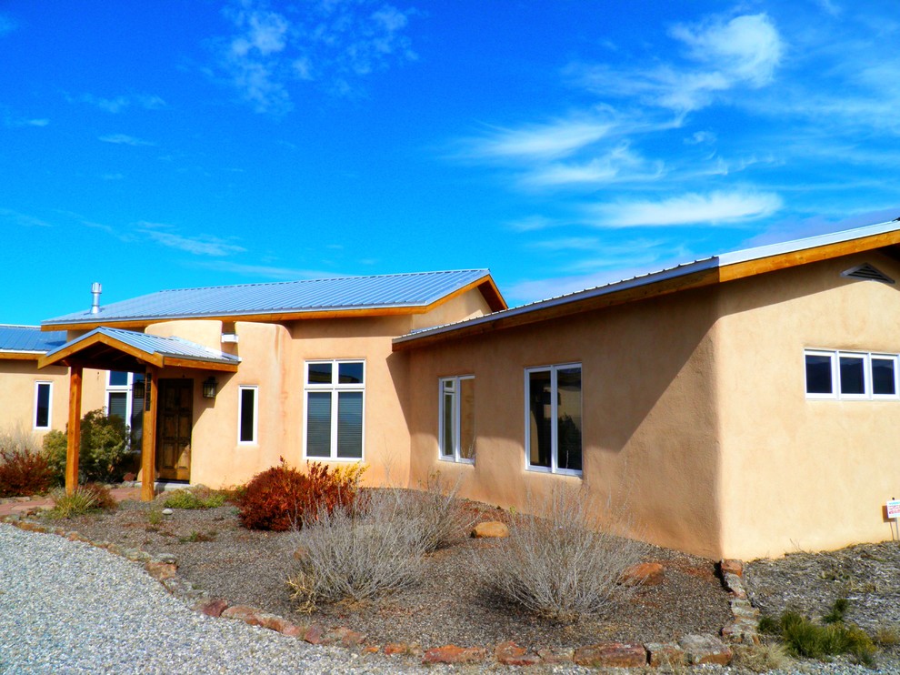 This is an example of a mid-sized one-storey concrete beige exterior in Albuquerque.