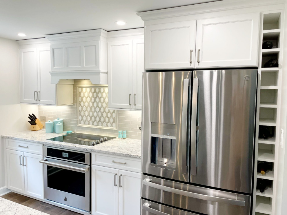 Mid-sized transitional kitchen photo with an undermount sink, recessed-panel cabinets, white cabinets, granite countertops, gray backsplash, stainless steel appliances and white countertops