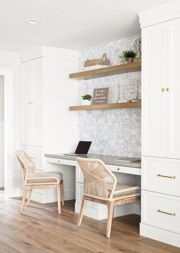 This is an example of a small study room in San Francisco with white walls, light hardwood floors, no fireplace, a built-in desk and beige floor.