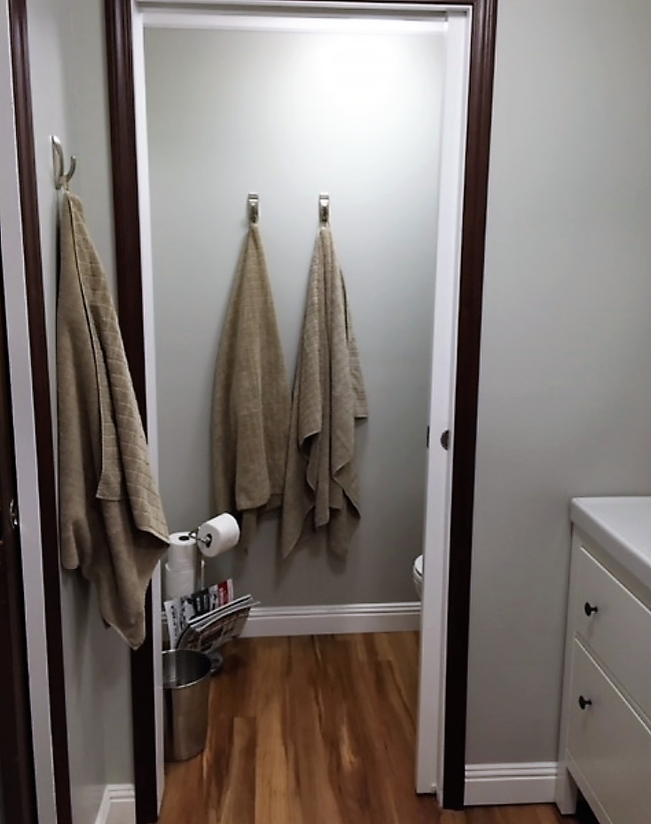 Photo of a small scandinavian master bathroom in Charlotte with flat-panel cabinets, white cabinets, an alcove shower, a two-piece toilet, gray tile, mosaic tile, grey walls, linoleum floors, an integrated sink, brown floor and a shower curtain.