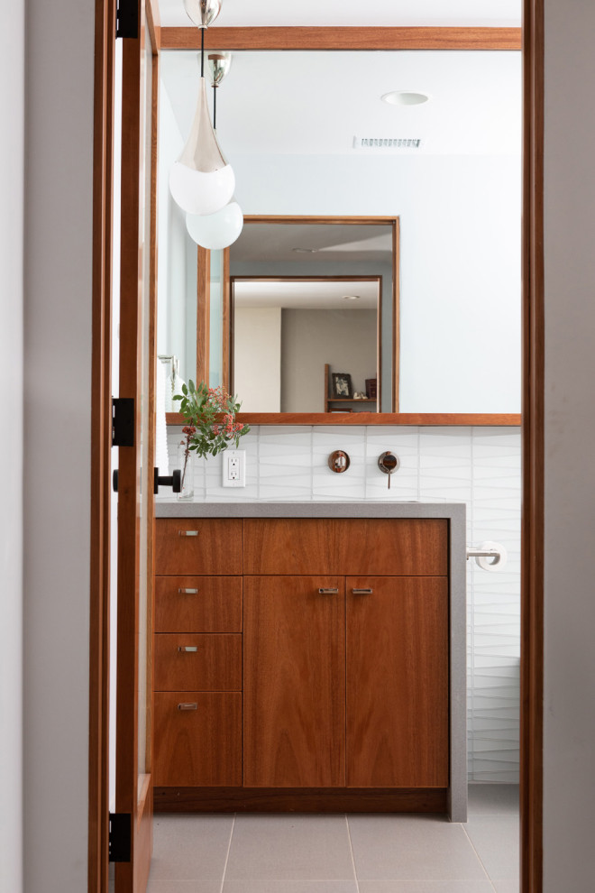 Modern inredning av ett litet grå grått badrum, med släta luckor, vit kakel, glaskakel, klinkergolv i porslin, ett undermonterad handfat, bänkskiva i kvarts och grått golv