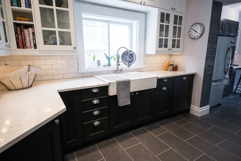 Transitional galley home design photo in Ottawa with recessed-panel cabinets, black cabinets, quartzite countertops, white backsplash, stainless steel appliances and no island