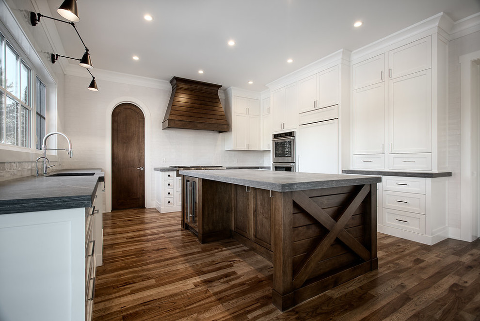 Example of a large transitional u-shaped eat-in kitchen design in Calgary with shaker cabinets, paneled appliances and an island