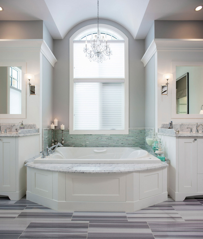 This is an example of a traditional bathroom in Calgary with an undermount sink, recessed-panel cabinets, white cabinets, a drop-in tub, green tile and matchstick tile.