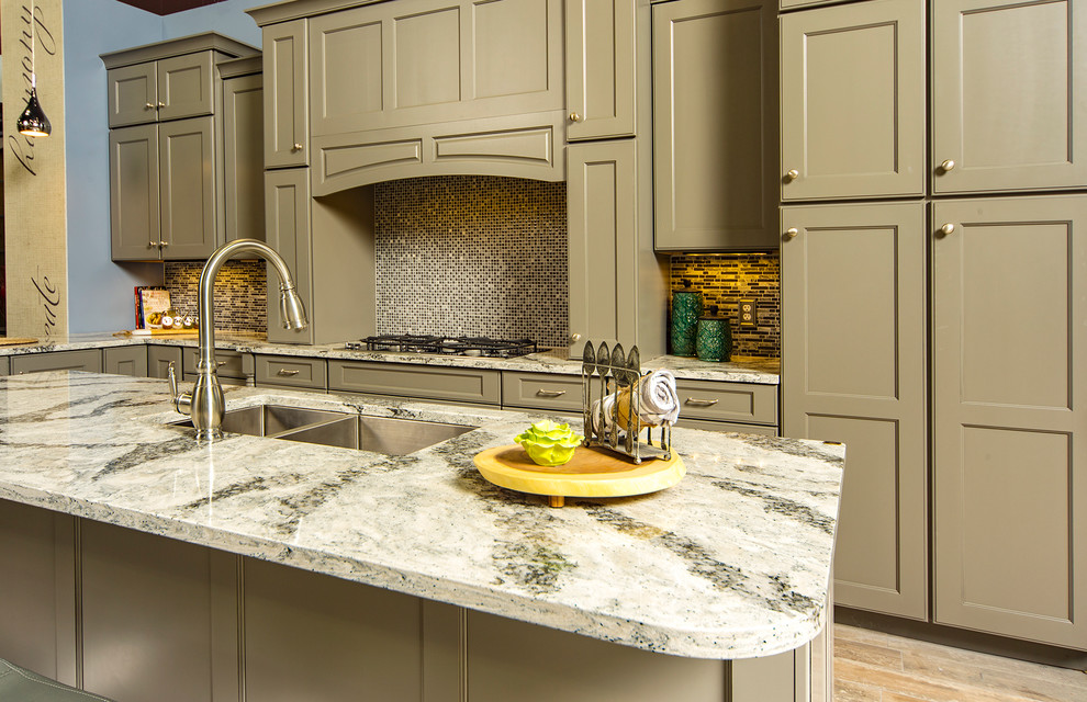 Example of a mid-sized classic l-shaped medium tone wood floor and brown floor kitchen design with a double-bowl sink, shaker cabinets, brown cabinets, granite countertops, multicolored backsplash, mosaic tile backsplash and an island