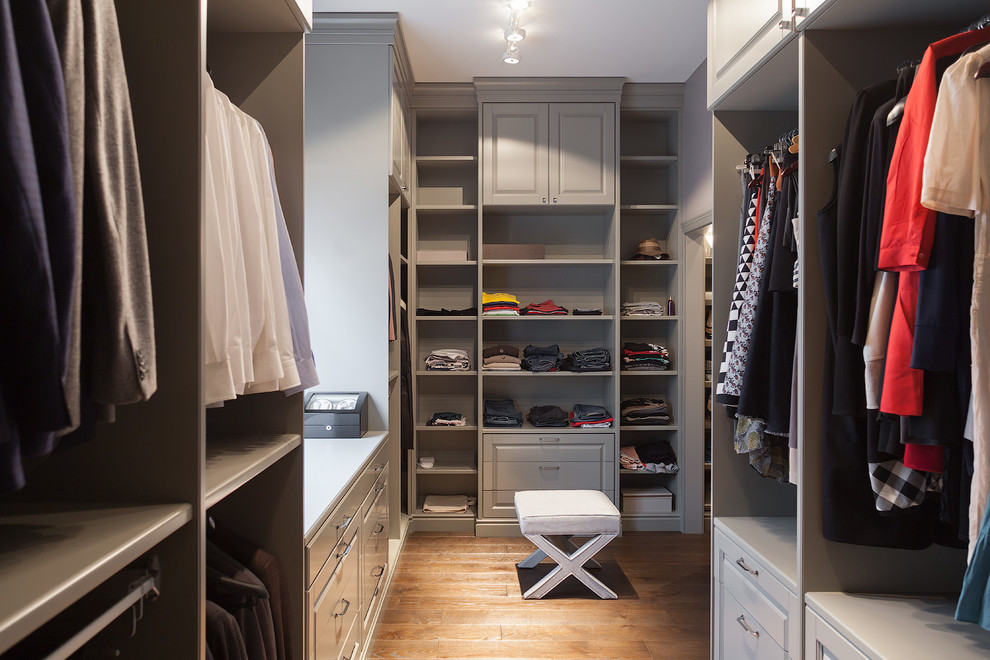 Inspiration for a large transitional gender-neutral dressing room in Other with grey cabinets, medium hardwood floors and open cabinets.