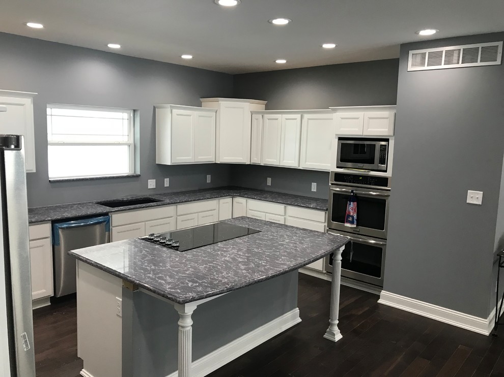 Kitchen - u-shaped kitchen idea with recessed-panel cabinets, white cabinets, stainless steel appliances and an island