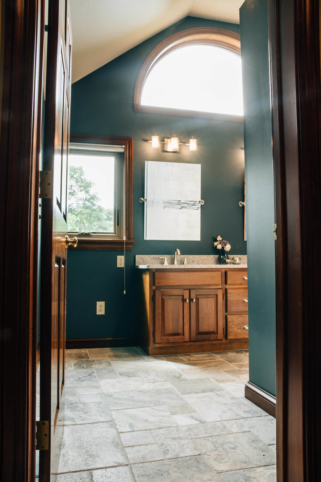Mid-sized transitional master beige tile and travertine tile travertine floor and beige floor alcove bathtub photo with raised-panel cabinets, dark wood cabinets, green walls, an undermount sink, granite countertops and gray countertops