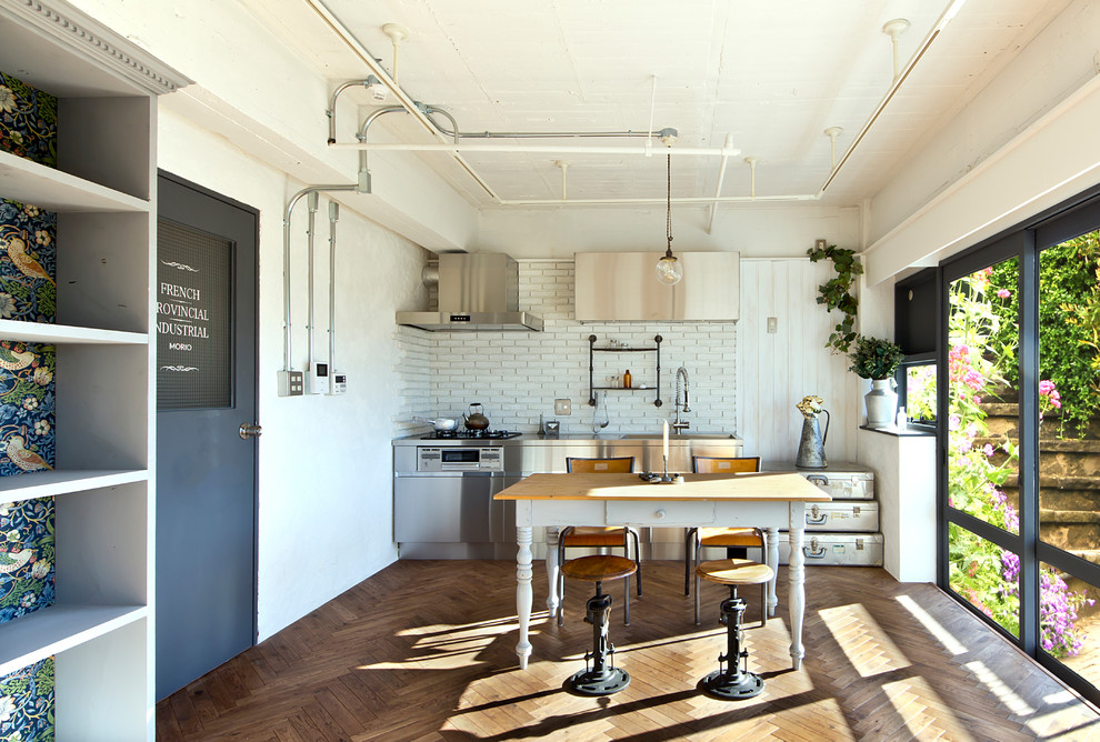 Inspiration for a small industrial single-wall eat-in kitchen in Tokyo with flat-panel cabinets, stainless steel cabinets, soapstone benchtops, white splashback, subway tile splashback, stainless steel appliances, medium hardwood floors, no island and brown floor.