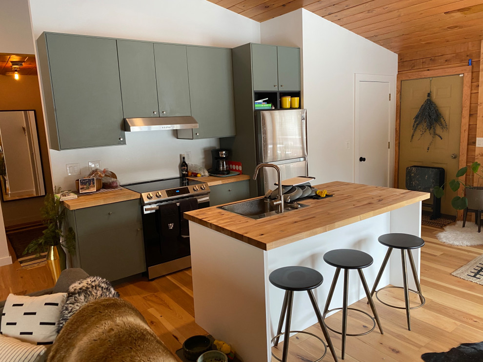 Immagine di una cucina minimalista di medie dimensioni con lavello da incasso, ante lisce, ante verdi, top in legno, elettrodomestici in acciaio inossidabile, pavimento in bambù e soffitto in perlinato