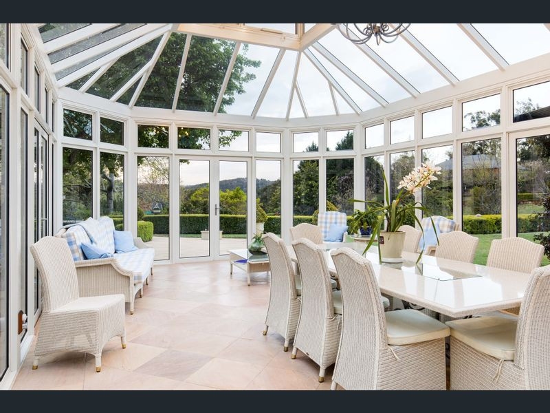Expansive traditional conservatory in Adelaide with terracotta flooring, a wood burning stove and a glass ceiling.