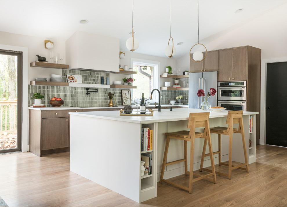 This is an example of a large midcentury l-shaped eat-in kitchen in Nashville with an undermount sink, flat-panel cabinets, medium wood cabinets, quartz benchtops, green splashback, porcelain splashback, stainless steel appliances, medium hardwood floors, with island, white benchtop and vaulted.