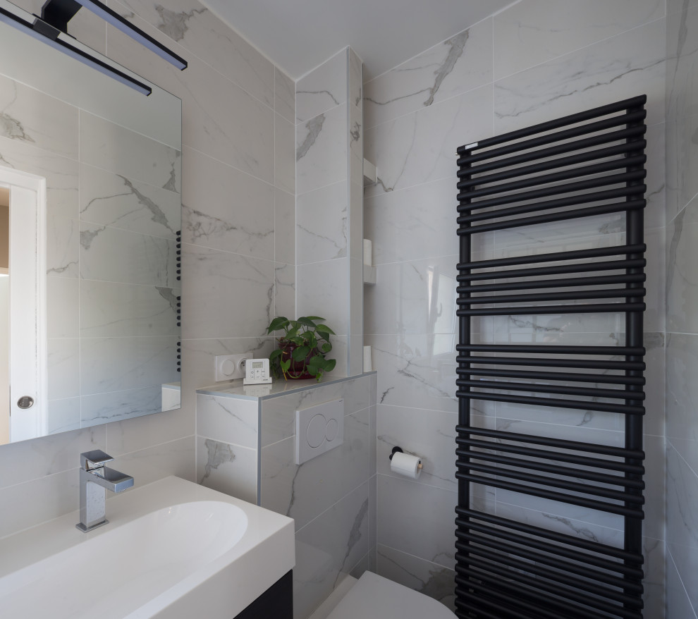 Design ideas for a small contemporary master bathroom in Paris with flat-panel cabinets, dark wood cabinets, a drop-in tub, a wall-mount toilet, white tile, marble, white walls, slate floors, a console sink, solid surface benchtops, black floor, white benchtops, a niche, a single vanity and a floating vanity.