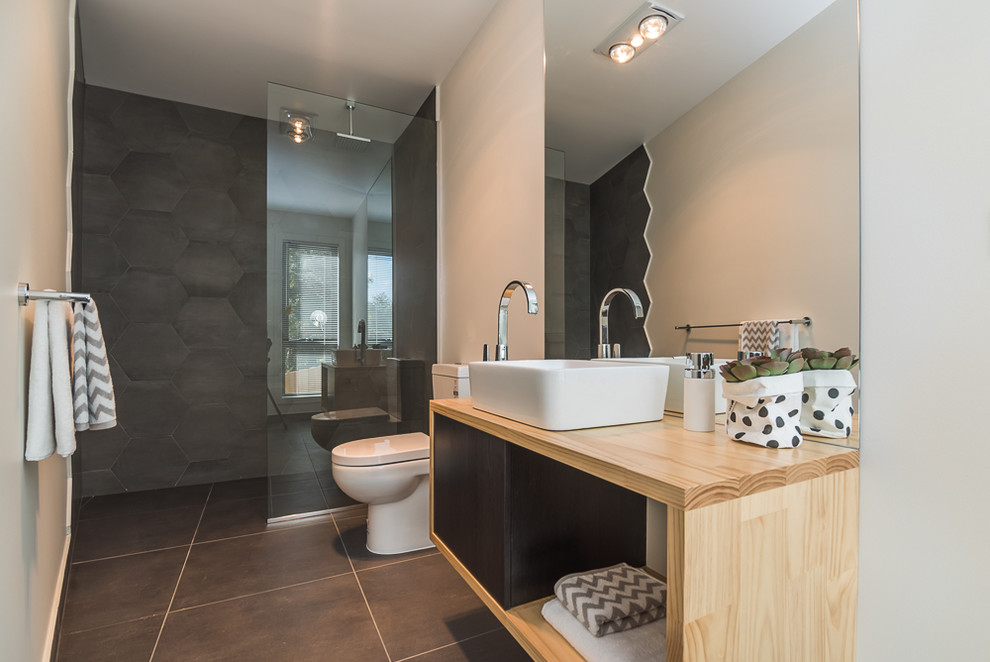 This is an example of a small contemporary master bathroom in Hobart with a vessel sink, open cabinets, light wood cabinets, wood benchtops, a one-piece toilet, ceramic tile, white walls, ceramic floors, an alcove shower and gray tile.