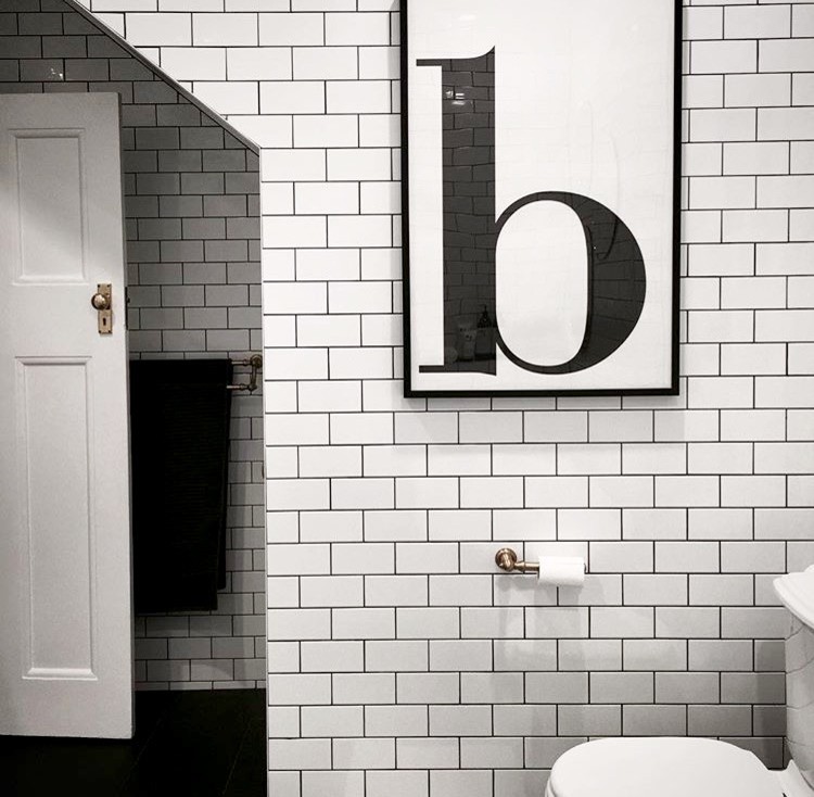 Inspiration for a mid-sized eclectic master bathroom in Sydney with flat-panel cabinets, medium wood cabinets, a freestanding tub, a curbless shower, a one-piece toilet, white tile, subway tile, white walls, ceramic floors, a console sink, wood benchtops, black floor and a hinged shower door.