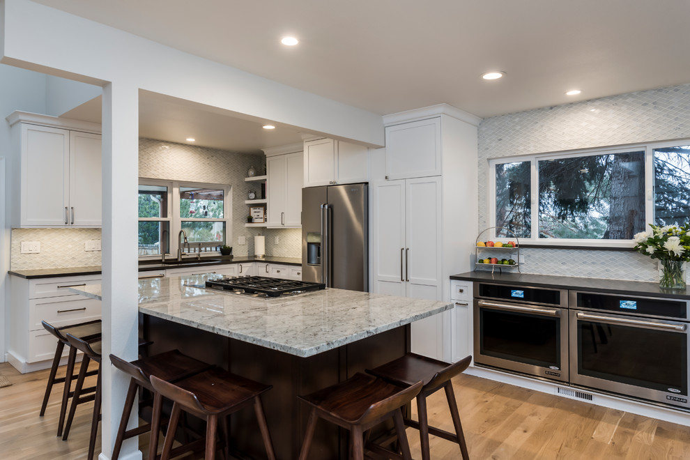 Large transitional light wood floor eat-in kitchen photo in Denver with a single-bowl sink, shaker cabinets, white cabinets, quartz countertops, white backsplash, marble backsplash, stainless steel appliances, two islands and gray countertops