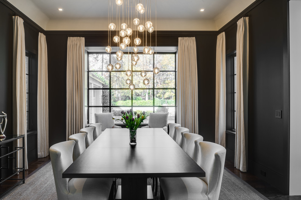 Photo of a transitional separate dining room in Atlanta with black walls, dark hardwood floors, no fireplace and brown floor.