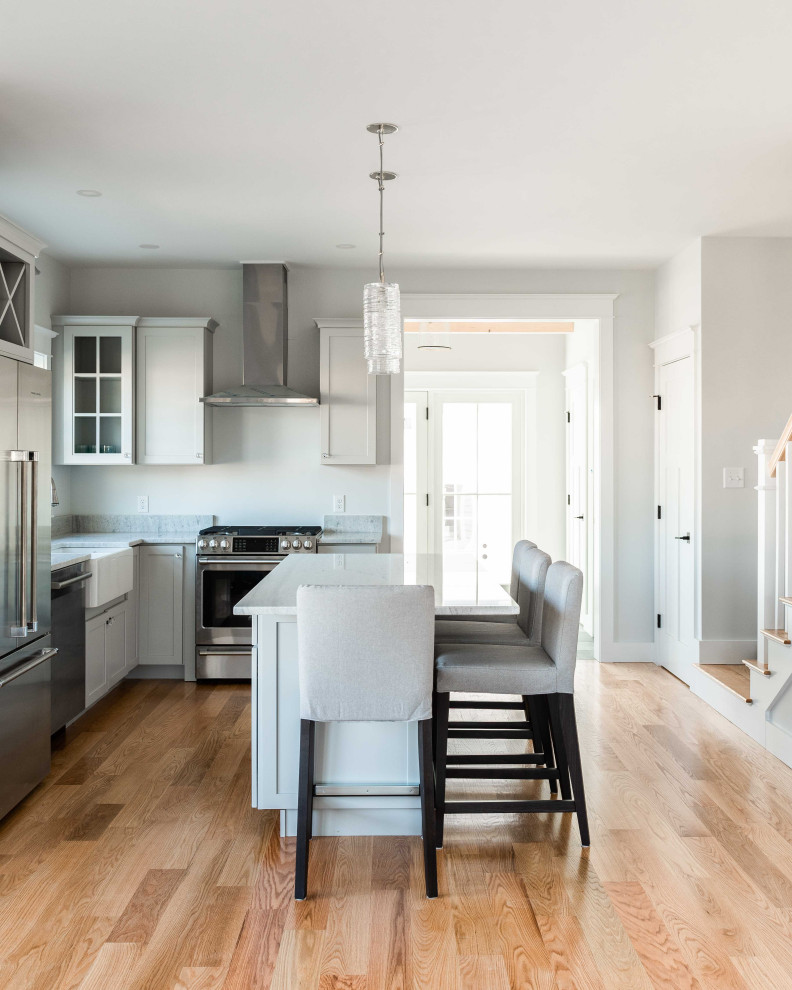 На фото: угловая кухня-гостиная среднего размера в классическом стиле с фасадами в стиле шейкер, серыми фасадами, гранитной столешницей, островом и белой столешницей с