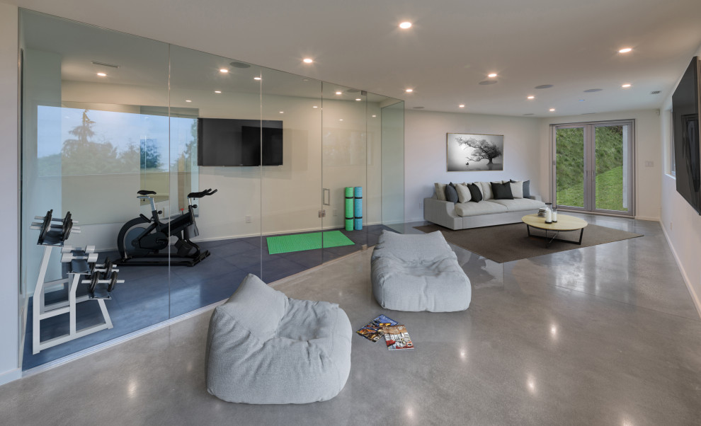 Источник вдохновения для домашнего уюта: большой универсальный домашний тренажерный зал в стиле модернизм с белыми стенами, бетонным полом и серым полом