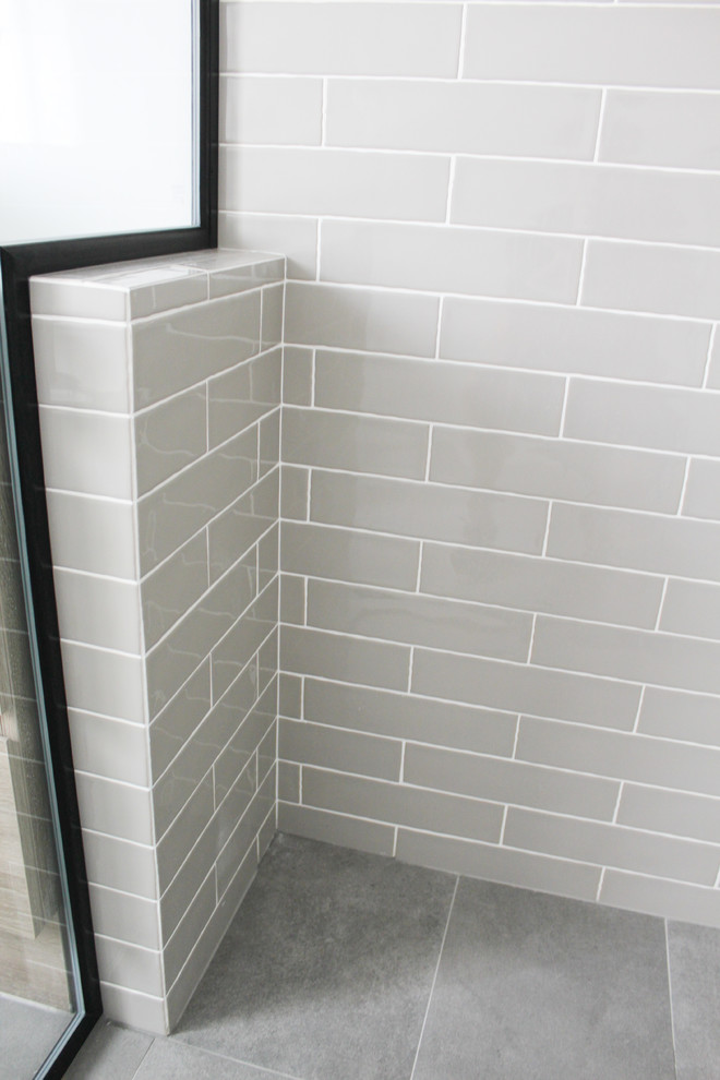 This is an example of a mid-sized modern master bathroom in Perth with flat-panel cabinets, dark wood cabinets, a corner shower, a one-piece toilet, white tile, subway tile, grey walls, porcelain floors, a vessel sink, solid surface benchtops, grey floor, a hinged shower door and white benchtops.