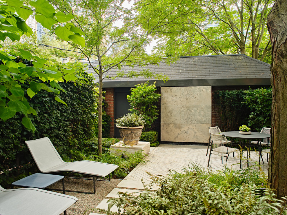 Small contemporary backyard partial sun formal garden in Toronto with with waterfall and natural stone pavers for spring.