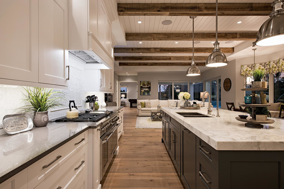 Photo of a contemporary galley eat-in kitchen in Miami with a double-bowl sink, recessed-panel cabinets, stainless steel appliances, light hardwood floors and with island.