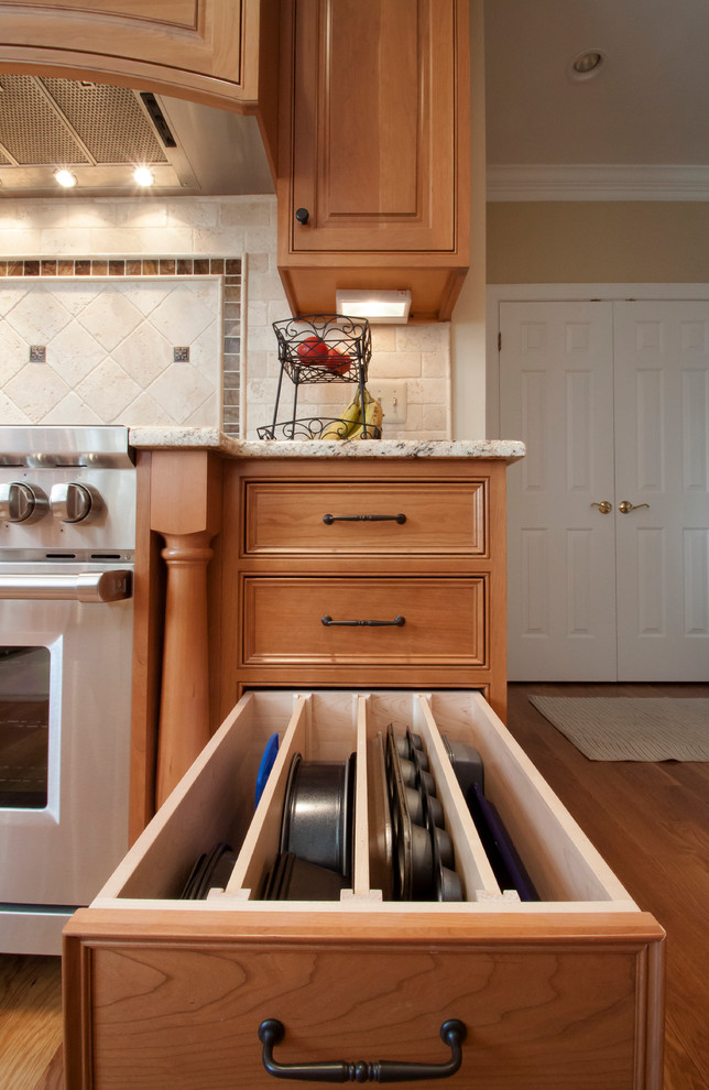 This is an example of a traditional kitchen in DC Metro with beaded inset cabinets and light wood cabinets.