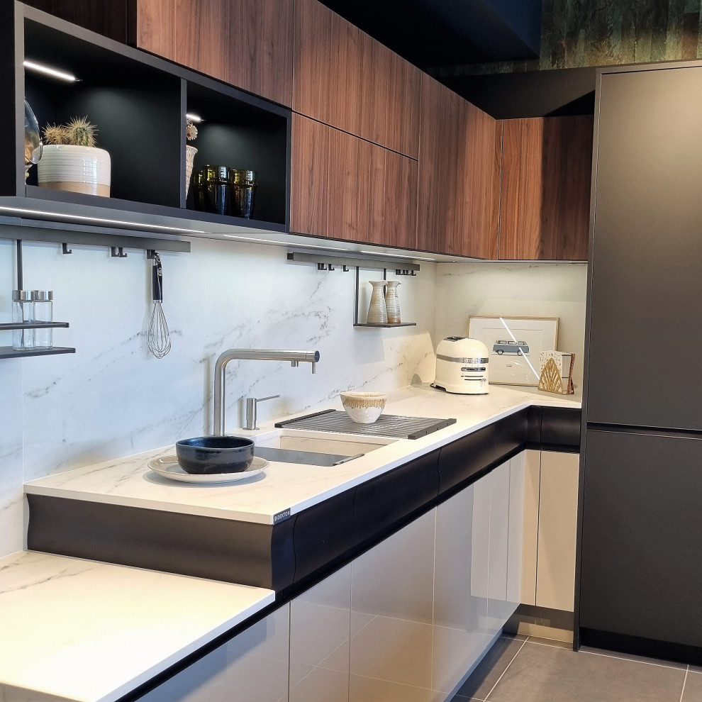 Esempio di una grande cucina moderna con lavello integrato, ante lisce, ante nere, top in granito, paraspruzzi bianco, paraspruzzi in granito, elettrodomestici neri e top bianco