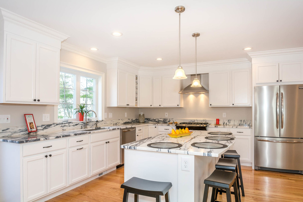 Eat-in kitchen - large transitional l-shaped brown floor and medium tone wood floor eat-in kitchen idea in Boston with an undermount sink, recessed-panel cabinets, white cabinets, stone slab backsplash, stainless steel appliances, an island and quartzite countertops