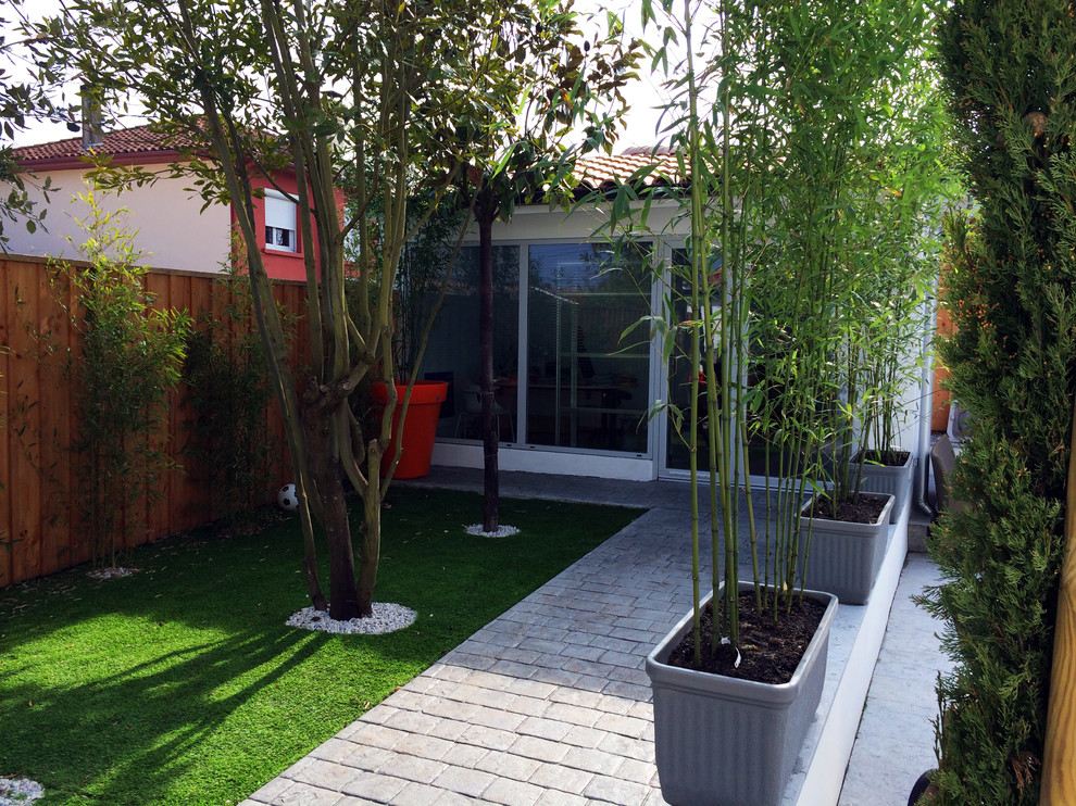 This is an example of a mid-sized contemporary partial sun garden for spring in Bordeaux with a container garden and concrete pavers.
