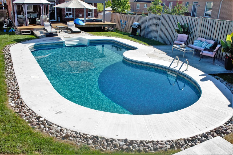 Example of a mid-sized transitional backyard concrete paver and custom-shaped lap pool design in Toronto