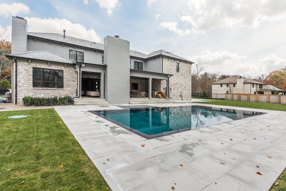 Design ideas for an expansive contemporary backyard custom-shaped infinity pool in Indianapolis with concrete pavers.