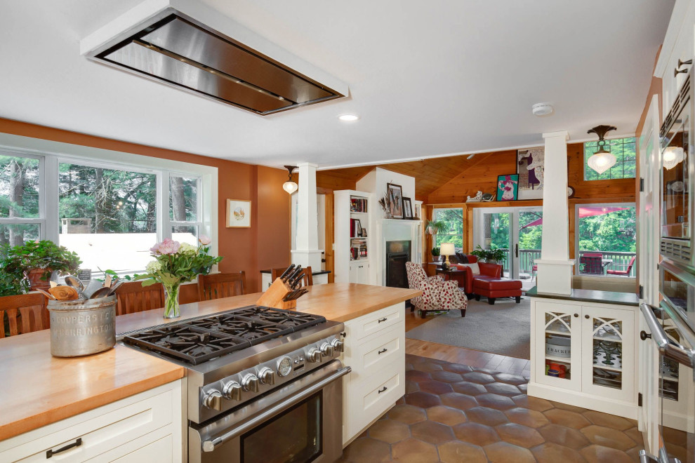 Design ideas for a large arts and crafts l-shaped eat-in kitchen in Providence with an undermount sink, shaker cabinets, white cabinets, wood benchtops, terra-cotta floors, with island, brown floor and black benchtop.