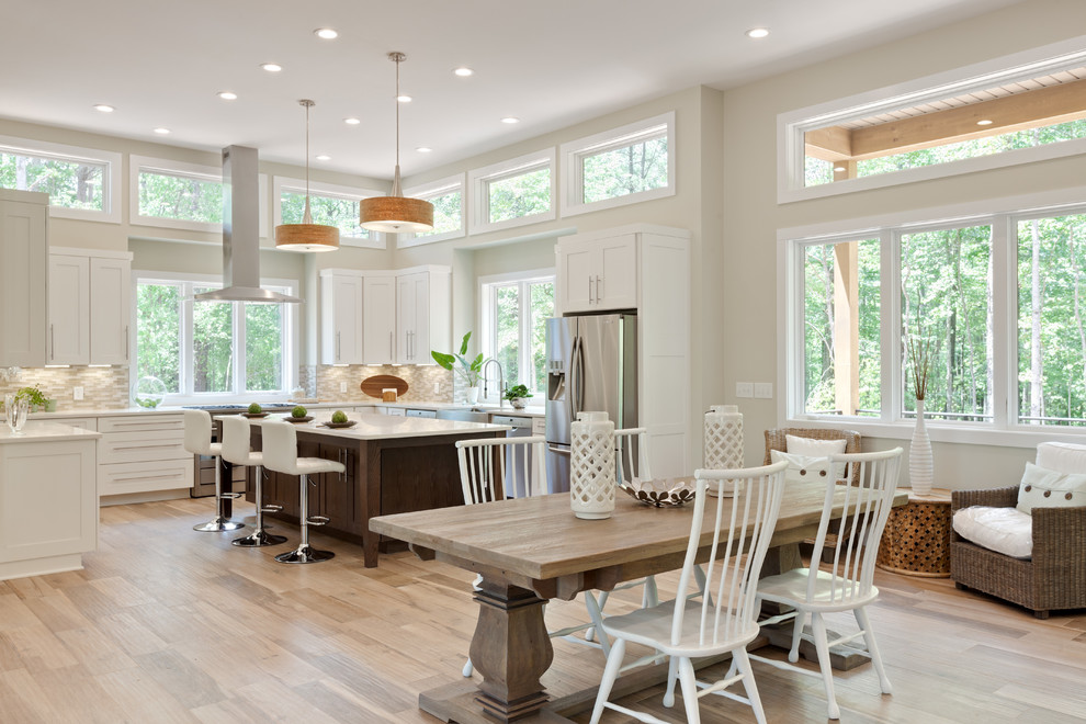 Design ideas for an expansive transitional u-shaped eat-in kitchen in Atlanta with a farmhouse sink, shaker cabinets, white cabinets, quartz benchtops, beige splashback, glass tile splashback, stainless steel appliances, porcelain floors, with island, beige floor and white benchtop.