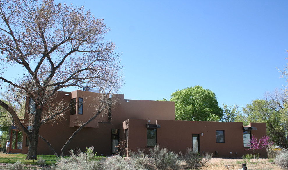 This is an example of a large two-storey stucco beige house exterior in Albuquerque with a flat roof.