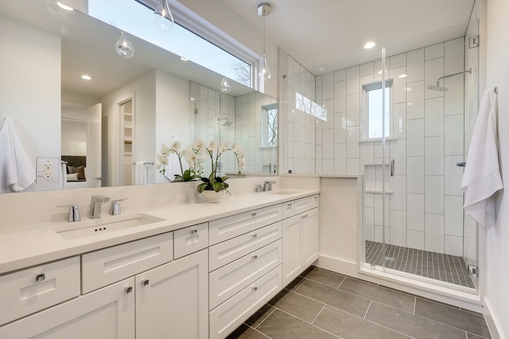 Photo of a large modern master bathroom in Austin with shaker cabinets, white cabinets, an alcove shower, white tile, porcelain tile, beige walls, laminate floors, an undermount sink, quartzite benchtops, brown floor, a hinged shower door and beige benchtops.
