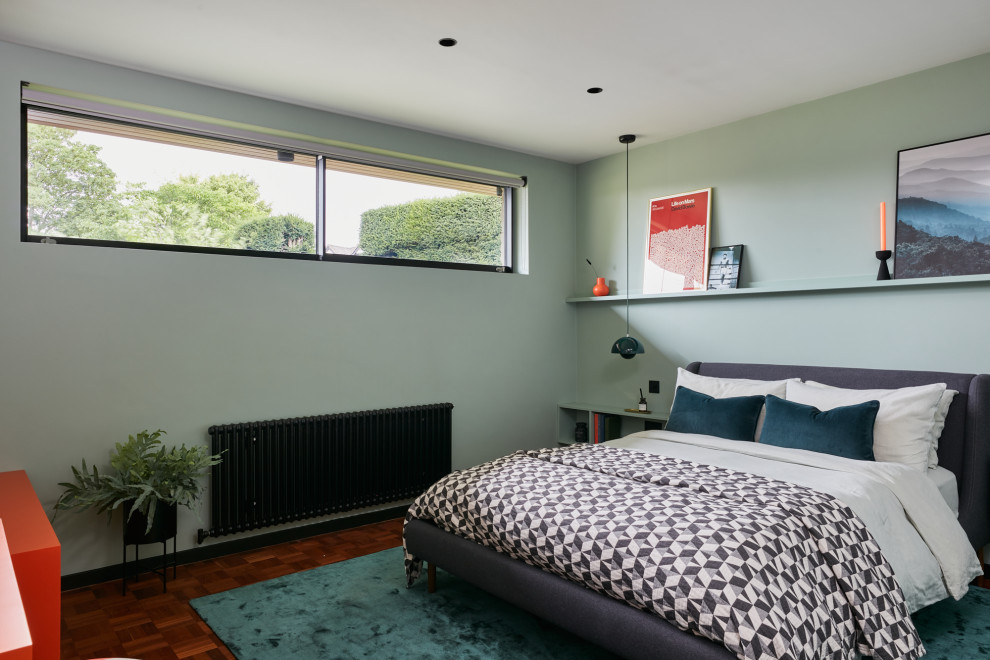 Mittelgroßes Retro Gästezimmer mit grüner Wandfarbe, dunklem Holzboden und braunem Boden in West Midlands