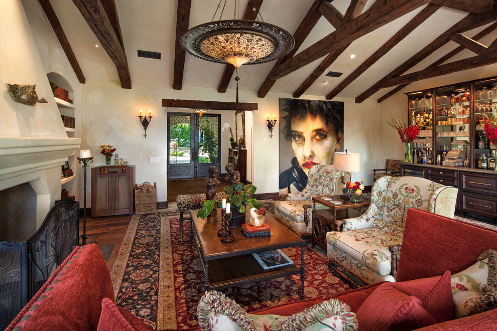 Large mediterranean enclosed living room in Santa Barbara with a home bar, beige walls, dark hardwood floors, a standard fireplace, a plaster fireplace surround and no tv.