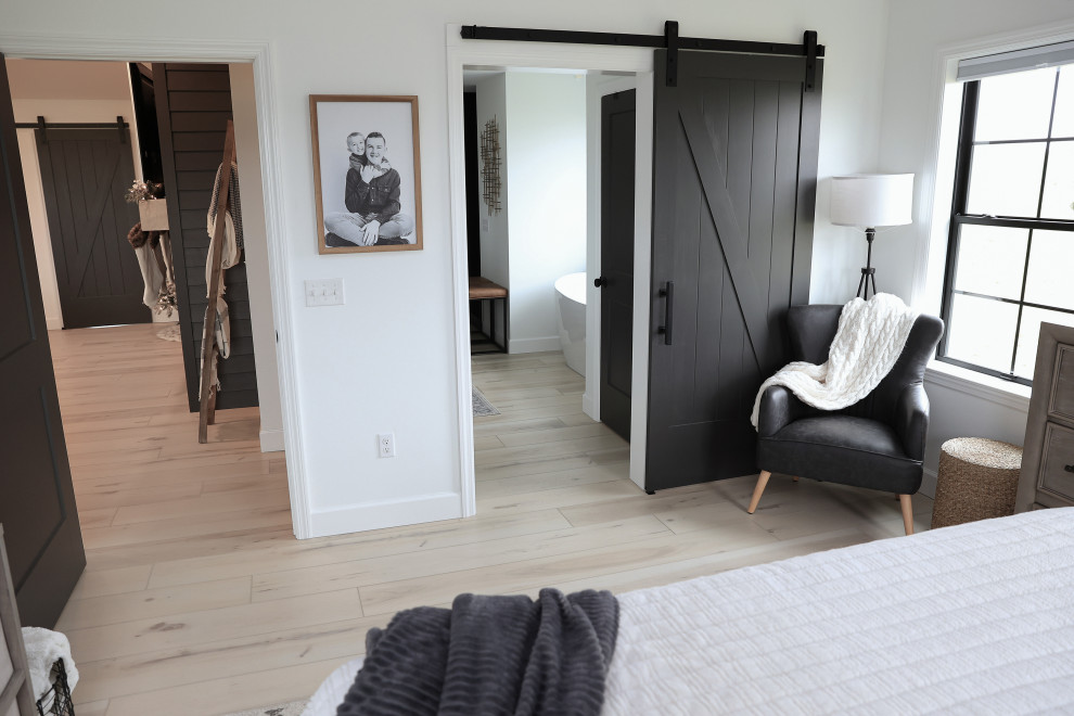 Large modern master bedroom in Philadelphia with black walls, vinyl floors, beige floor and decorative wall panelling.