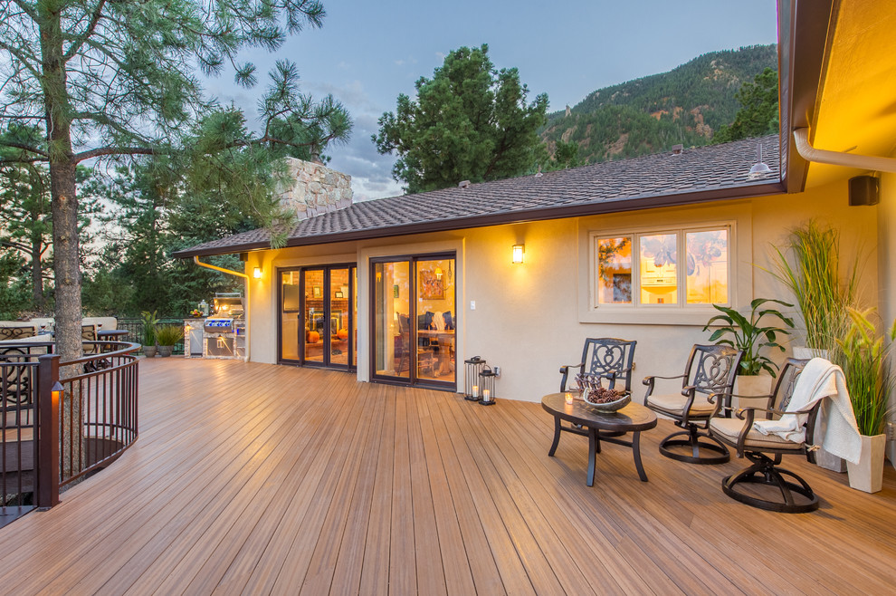 This is an example of a large traditional backyard and first floor deck in Other with with fireplace.