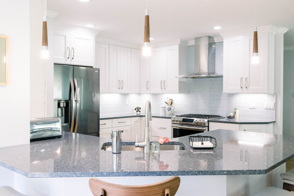 This is an example of a mid-sized kitchen in Cincinnati with a single-bowl sink, shaker cabinets, white cabinets, quartz benchtops, blue splashback, subway tile splashback, stainless steel appliances, light hardwood floors, brown floor and blue benchtop.