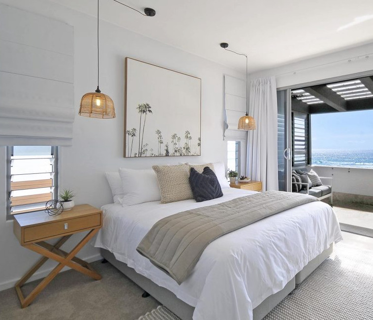 Ejemplo de dormitorio principal costero grande con paredes blancas, moqueta y suelo beige