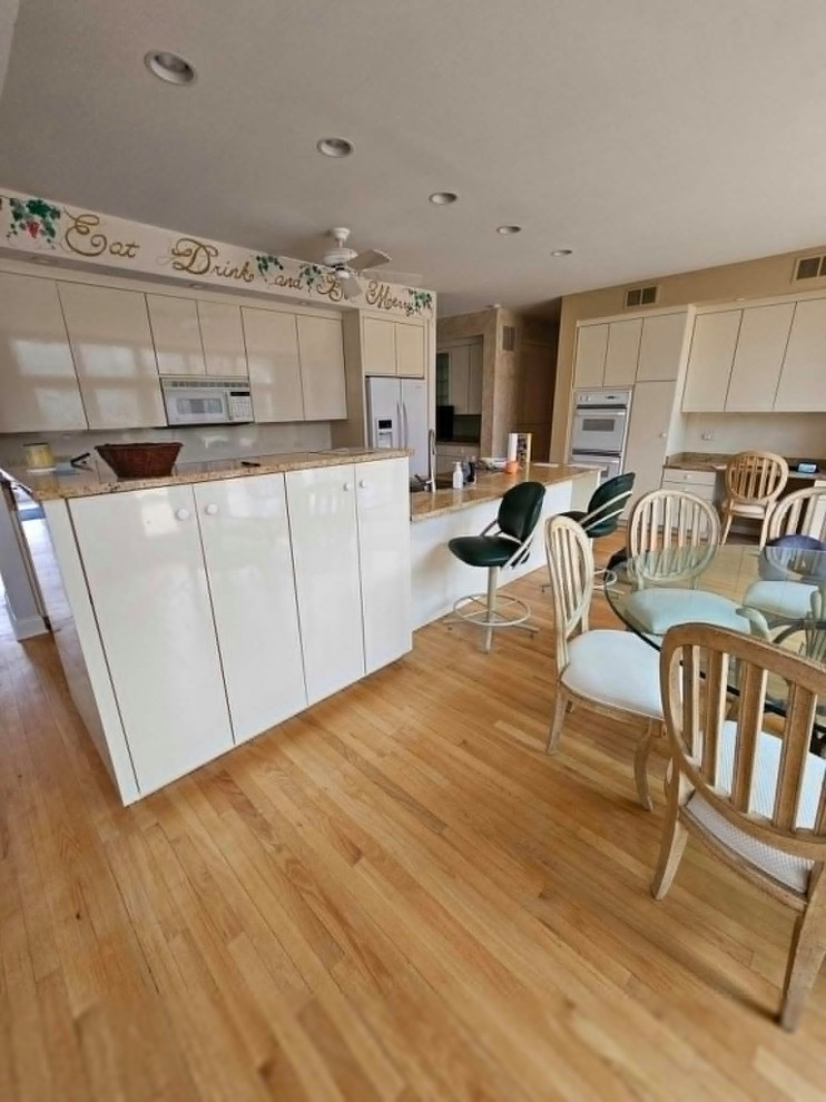 Large transitional medium tone wood floor and brown floor eat-in kitchen photo in Chicago with an undermount sink, shaker cabinets, medium tone wood cabinets, quartz countertops, multicolored backsplash, stone tile backsplash, stainless steel appliances, an island and white countertops