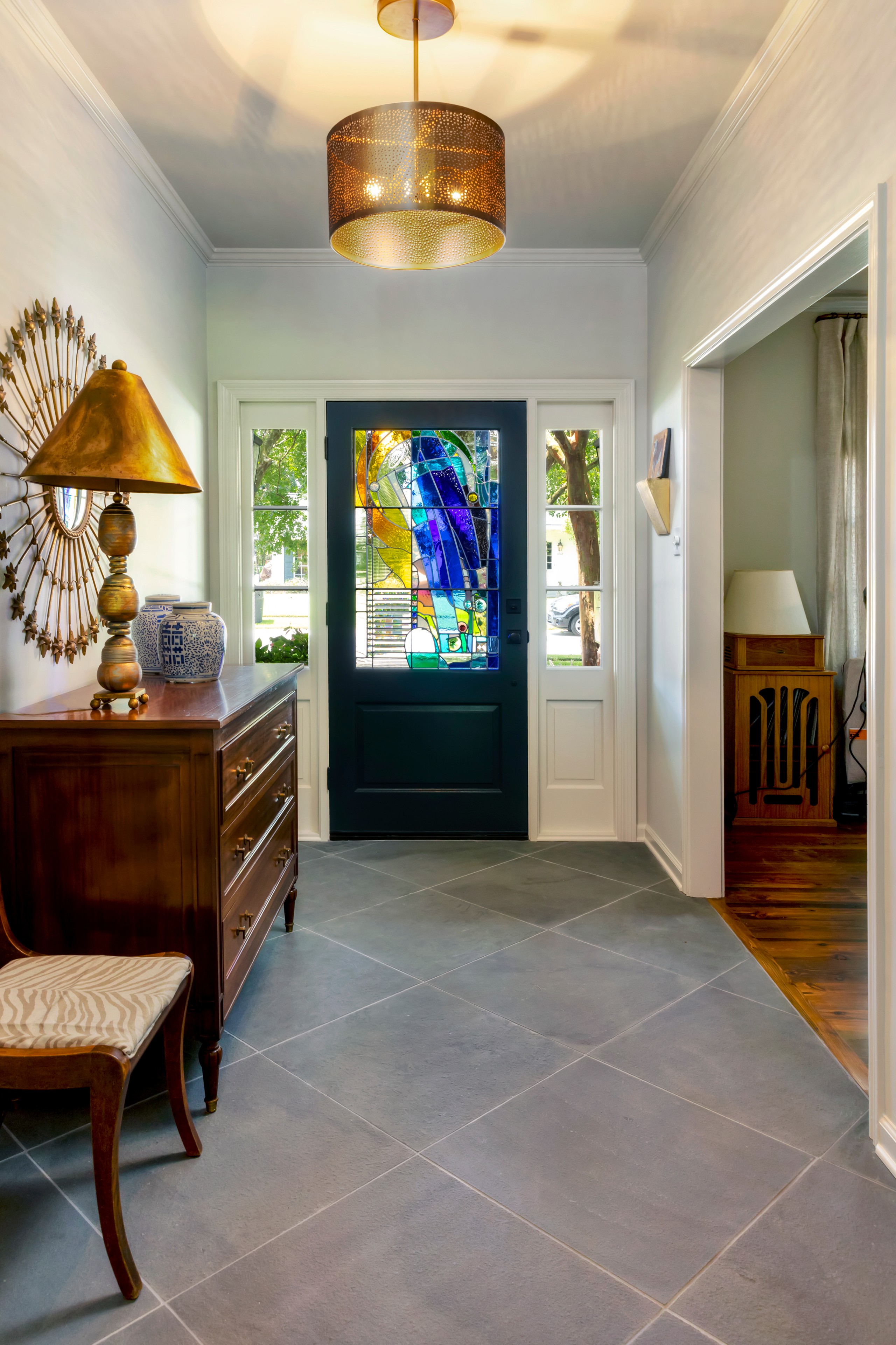 Example of a mid-sized transitional gray floor entryway design in New Orleans with gray walls and a blue front door