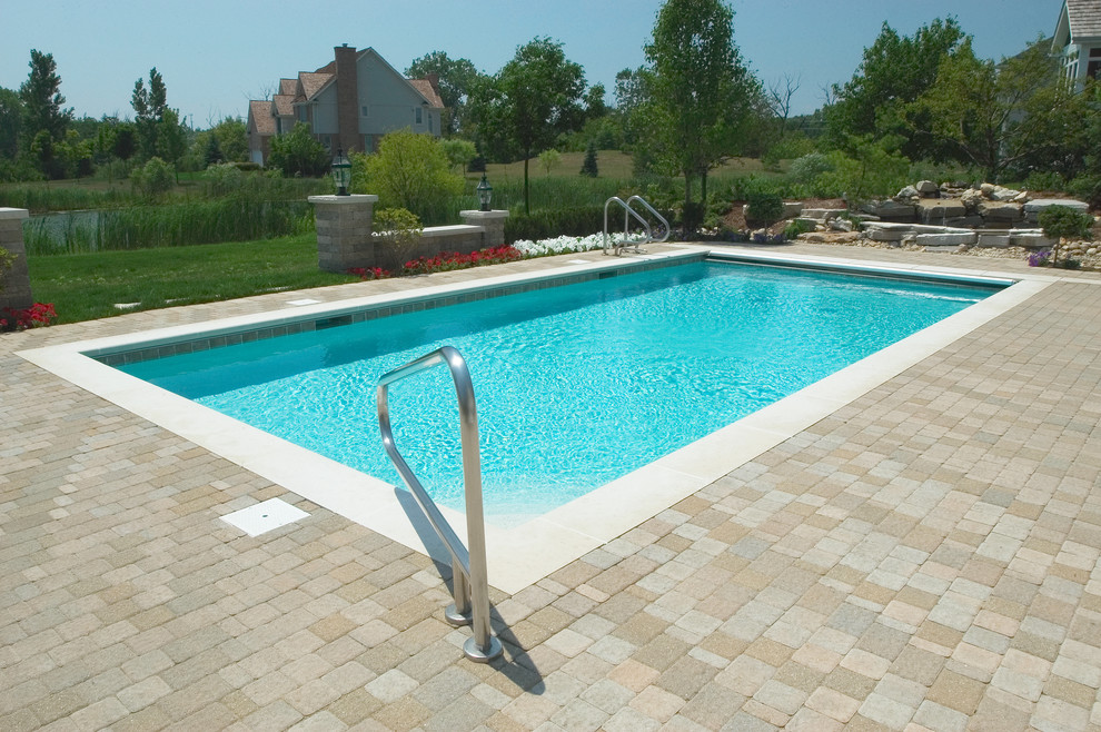 Photo of a small traditional backyard rectangular lap pool in Chicago with concrete pavers.