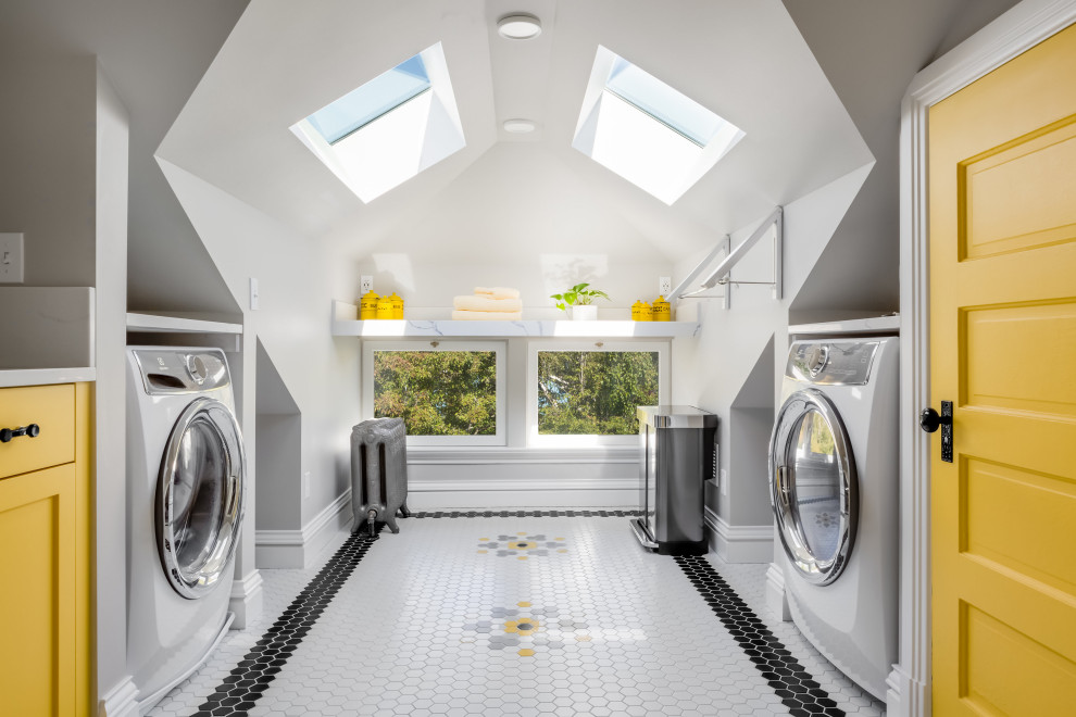 Photo of a mid-sized arts and crafts u-shaped dedicated laundry room in Seattle with a farmhouse sink, shaker cabinets, yellow cabinets, white splashback, grey walls, porcelain floors, white benchtop, vaulted, quartz benchtops and engineered quartz splashback.