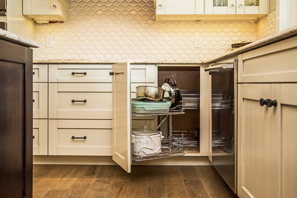 Example of a transitional medium tone wood floor kitchen design in Calgary with an undermount sink, shaker cabinets, white cabinets, quartz countertops, white backsplash, porcelain backsplash and stainless steel appliances